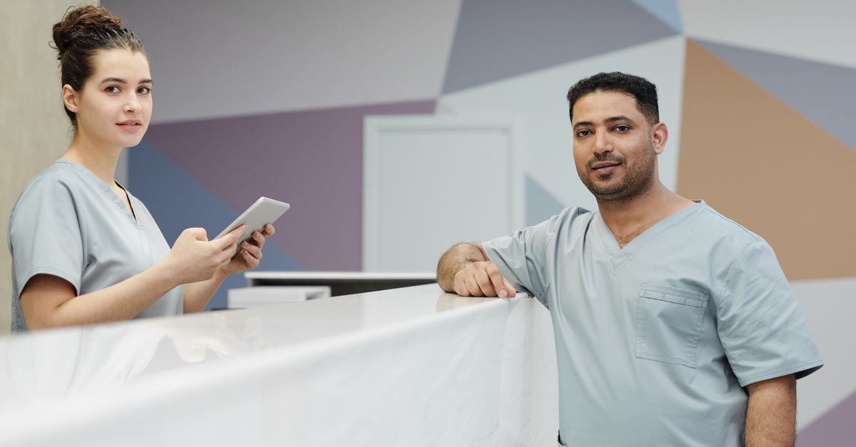 Médico com tablet organizando agenda digital em consultório moderno