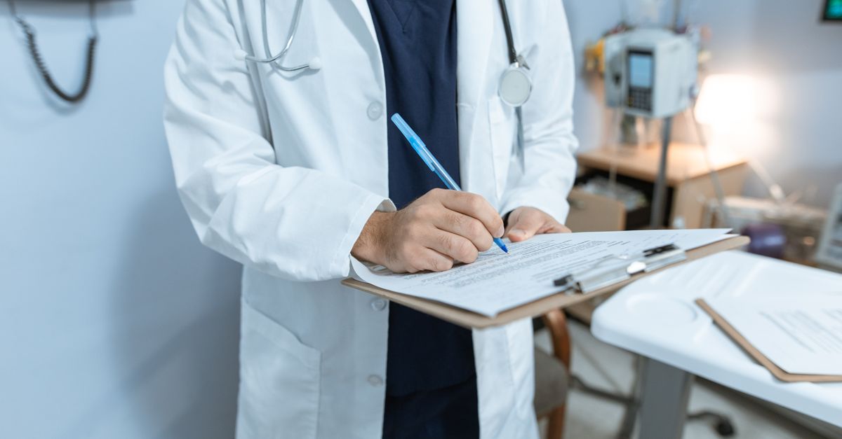 Médico de jaleco branco analisando documentos fiscais e calculadora — IRPF pessoa física 2026