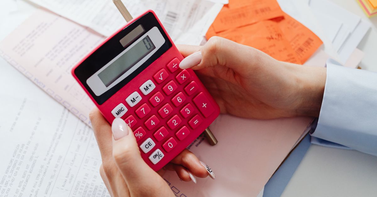 Médico calculando finanças com calculadora e documentos na mesa