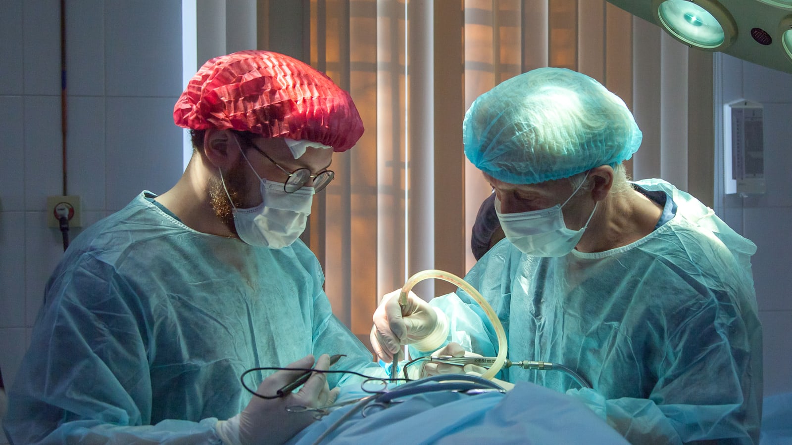 Mão de médico segurando celular com notificação WhatsApp em corredor hospitalar