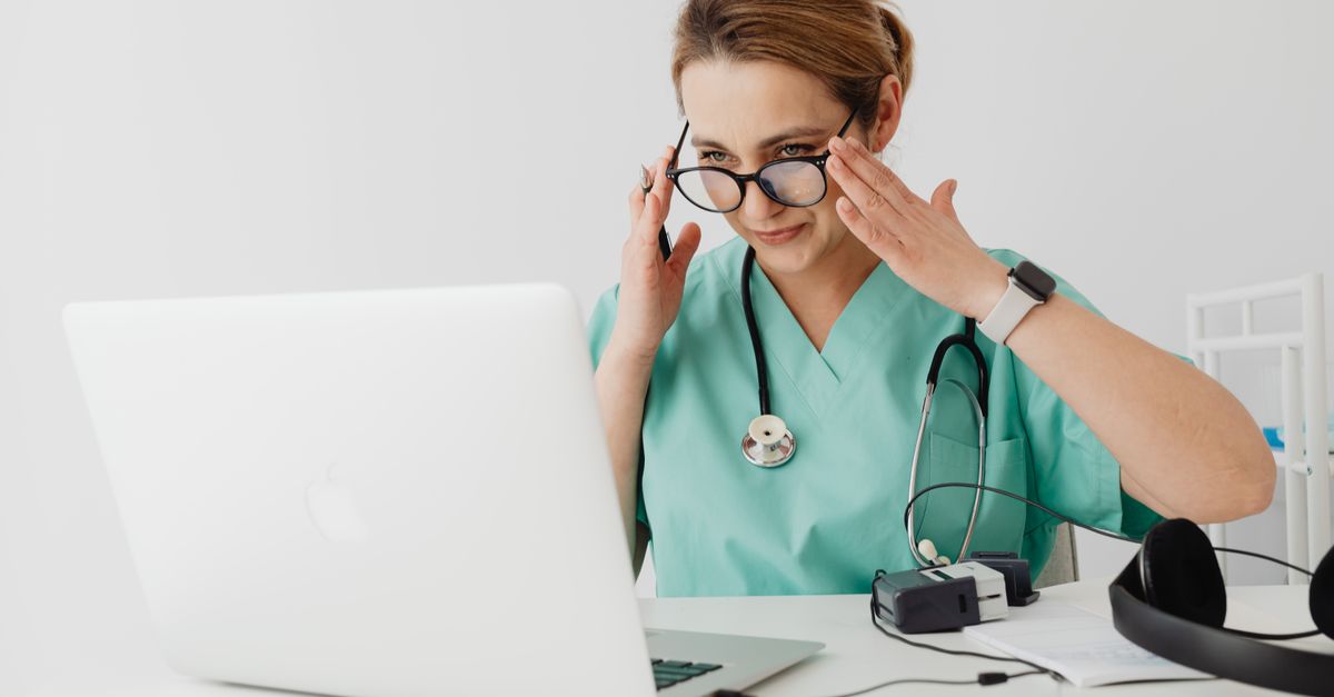Médico em videochamada com paciente, tela de computador com formulário de consentimento